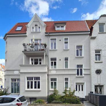 Ansicht des grundsanierten 4-Familienhauses im Stile des Klassizismus von 1922 mit Putzfassade und historisch stimmigen, 2-flügeligen Fenstern mit senkrechten Sprossen im oberen Drittel